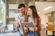 © Miljan Živković - couple stand in the kitchen and use digital tablet for online shopping