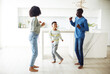 © Raisa Kanareva - Young afro american family - mom, dad and son dancing at home. Happy together.