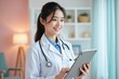 © yuntunen - Young female doctor smiling while using tablet in modern clinic