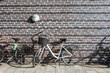 © yaqui_villegas - Urban bicycles parked in sunlight near modern dark brick wall. Soft shadows and repeating architectural textures define the Copenhagen street atmosphere.