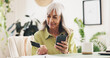 © peopleimages.com - Phone, credit card and mature woman in home for online shopping or ecommerce order with sale. Relax, cellphone and female person with banking app for payment, transaction or deposit in house.