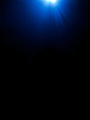 Wall Mural - bright blue light effect with rays and highlights, glow particle, black background