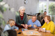 © JackF - Happy elderly woman playing board game with group of friends at table. Concept of socialization of older adults