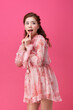 © Dialogue Frame - Young Woman in Pink Pattern Dress Posing on Pink Background