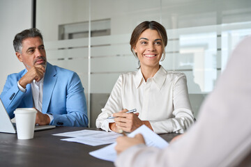 Fototapete - Happy busy business people corporate executive team talking at group meeting. Smiling female manager working with colleagues in office, consulting investor or client, conducting job interview.