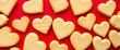 © DITSARAPHAN - Heart-shaped cookies arranged on a red backdrop, confectionery, treat