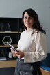 © Andrii Zastrozhnov - Caucasian young female in office setting holding notebook smiling