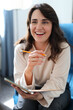© Andrii Zastrozhnov - Caucasian female adult smiling and working on tablet in casual setting