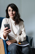 © Andrii Zastrozhnov - Caucasian female adult taking selfie with smartphone in modern office setting