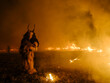 © PATMALUPHOTO - A Krampus figure in a furry suit and horned mask stands amidst smoke and fire. Another figure is visible in the background. Krampus and St Nicholas, 5 December in Tarvisio, Italy.