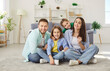 © Studio Romantic - Happy smiling family at home together, parents, cute kids portrait having joy sitting together on warm floor carpet, cheerful couple laughing with little active children son, daughter in living room