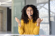 © Liubomir - A smiling woman with curly hair wearing a headset gestures during a call, looking at the camera.