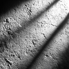 Poster - Abstract Wall with Sunlight Stripes: A monochromatic textured surface with linear shadows creating a dramatic and minimalist scene.