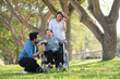 © Mallika - Senior Asian Woman in Wheelchair with Family Outdoors ,Caregiving and Support