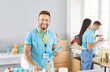 © Studio Romantic - Portrait of young smiling man volunteer sorting donations of foodstuffs for charity food drive volunteering in food bank in charitable foundation helping poor people in need. Humanitarian aid concept