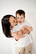 © Any Grant - a mother and child hug and play, having fun on a white isolated background, a mother and a small child, a mother and son.