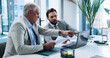 © peopleimages.com - Business men, laptop and team planning in office for discussion and insurance training with paper. Computer, meeting and conversation with boss for report, risk management and explain idea for policy