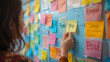 © Stacy - Woman adding sticky note with Thank You on colorful board for teamwork appreciation