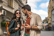 © Srdjan - Couple goals. Young man and woman met on work and travel, fell in love, exploring new city together on a beautiful sunny day. Expatriates enjoying company walking on city streets.