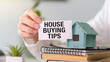 © Pawel - Top view text House Buying Tips in hand with little house. Property concept.
