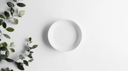 Poster - Empty white plate with green leaves on white background.