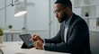 © Marcos - Man in suit analyzing financial data on a tablet in an office