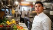 © Daiki - A young Hispanic male chef stands confidently in a vibrant kitchen setting, showcasing his culinary skills amid a backdrop of fresh ingredients and activity.