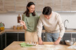 © Pixel-Shot - Young couple kneading dough together in kitchen