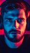 © Reyhan - Close-up portrait of a man wearing headphones, illuminated by vibrant colors.