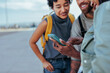© bernardbodo - Tourists using smart phone and smiling during their vacation