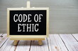 © may1985 - Code Of Ethic text written on chalkboard with easel on wooden background