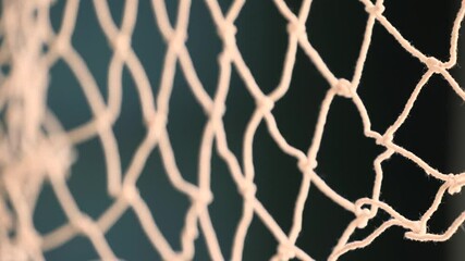 close-up of a white net made from thick threads, possibly used for football or fishing. detailed tex