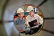 © BESTIMAGE - partner woman engineer assistant in helmet inspection check heavy machine construction installation in industrial metal roof roll sheet factory with colleague manager. partnership operation factory