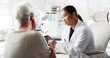 © peopleimages.com - Tablet, doctor and conversation with patient for healthcare report, test results or help. Medical professional, tech and consultation with senior woman for checkup, questions or symptoms in hospital