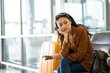 © Chanakon - Unhappy young woman traveler disappointed with flight delay or cancelation while waiting at airport terminal, female tourist upset after receiving bad news when sitting at airline lounge.