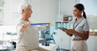 © peopleimages.com - Elderly woman, physiotherapist and resistance band with stretching, smile and healthcare services for recovery. People, happy and exercise with tablet, help and injury for rehabilitation at clinic