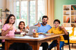 © StockImageFactory - Parents teaching kids at home using laptop and books during study session in living room