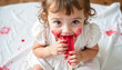 © Natallia - Cheerful child enjoying red popsicle while sitting on white blanket