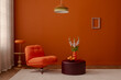 © FollowTheFlow - Retro-inspired interior with orange lounge chair, colorful pendant lamp, and sculptural vase. Warm orange walls and playful shapes create a cheerful atmosphere...