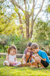 © Austockphoto - Children sitting on grass sorting out baskets of Easter eggs