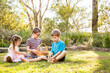 © Austockphoto - Children sitting on grass sorting out baskets of Easter eggs