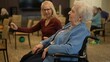 © Robert Peak - A lively atmosphere fills the community center as seniors participate in group activities. One smiling facilitator interacts with a resident in a wheelchair.