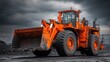 © Art - Orange bulldozer stands ready on a dark surface under a cloudy sky.