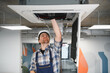 © Serhii - Hvac technician repairing air conditioning unit in office building
