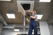 © Serhii - Hvac technician repairing air conditioning unit in office building