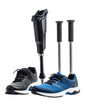 © Feri - Arrangement of orthopedic equipment featuring a prosthetic leg two walking sticks and pairs of athletic shoes against a transparent backdrop showcasing medical devices and support