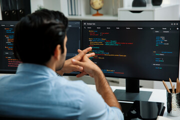 Concentrating in smart IT developer working software development coding on two pc screen, creating virus firmware application program for latest update version on website at modern office. Surmise.
