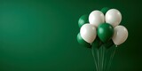 Green and white balloons grouped together on a solid green background for a festive celebration