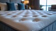 © Enggal Pitoyo - Close-up of a plush, quilted mattress, showcasing its texture and comfort.  A blurred background hints at a luxurious bedroom setting