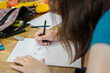 © Austockphoto - Young teenage girl creating artwork, drawing Manga and stencilling at the table